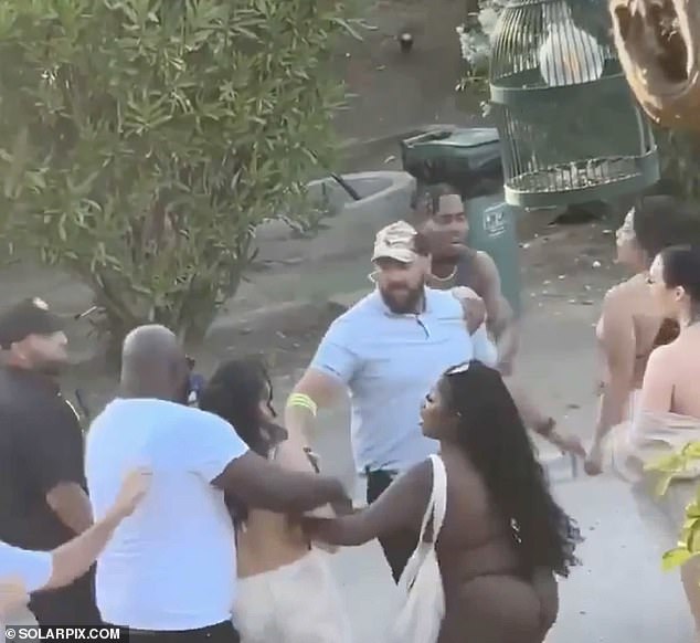 Security guards try to keep feuding partygoers apart in the club's parking lot