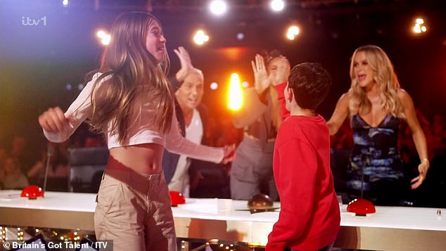 “Okay, okay, do it,” Simon said, gesturing to Eric as he and Hollie, 12, jumped to their feet and rushed to the judges' box, slamming the golden buzzer and sending Harbow through to the live semifinals