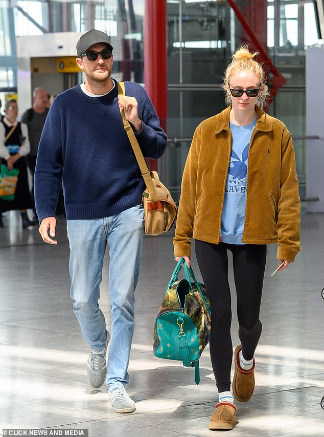 Sophie Turner cut a casual figure in a blue Playboy sweatshirt as she arrived at Heathrow Airport with boyfriend Peregrine Pearson on Sunday