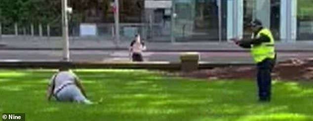 Shocking images have emerged of a man being confronted by police (pictured) after he allegedly stabbed a male police officer near the Anzac Memorial in Sydney's Hyde Park on Sunday afternoon.