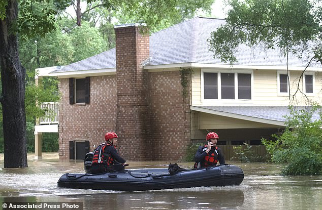 Caney Creek Fire and Rescue responders carry a dog from a flooded area