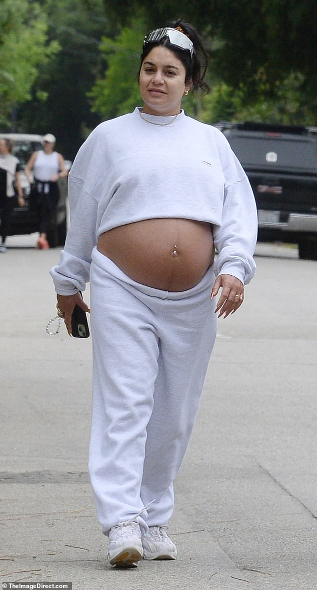 Vanessa Hudgens showed off her growing baby bump during a walk in Los Angeles on Saturday.  For her outing, the 35-year-old actress dressed up in a light gray sweatshirt, which she pulled up to expose her stomach, and cozy matching sweatpants.