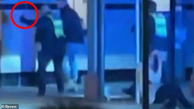 A police officer is pictured about to beat a man with a baton outside a pub in Yea, Victoria