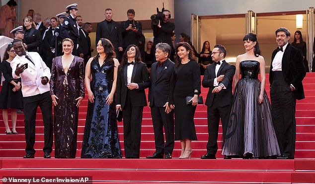 Jury president Greta Gerwig, second from left, poses with judges Omar Sy, from left, Lily Gladstone, Nadine Labaki, Kore-eda Hirokazu, Ebru Ceylan, JA Bayona, Eva Green and Pierfrancesco Favino at the opening festival