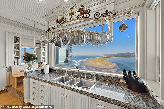 Behind the kitchen counter is a wide window through which someone cooking can look into the bay window