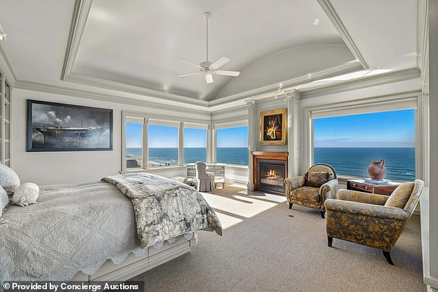 The master bedroom has a working fireplace, large windows overlooking the ocean and beautiful crown molding