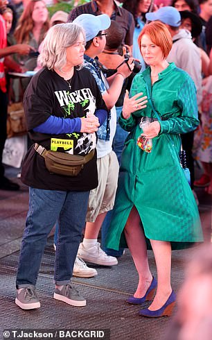 Nixon wore an emerald green, satin trench coat-inspired dress with a thick, black belt that cinched her waist