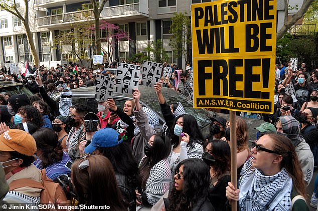 Pro-Palestinian protesters gather outside New York University's John A. Paulson Center on May 3, holding signs expressing their views.