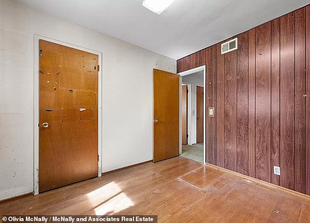 The walls are covered with old wallpaper or wood paneling from floor to ceiling