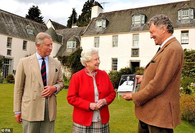 Queen Elizabeth and her son Charles, then the Prince of Wales, are presented with a copy of the official biography of the Queen Mother by author William Shawcross in 2009