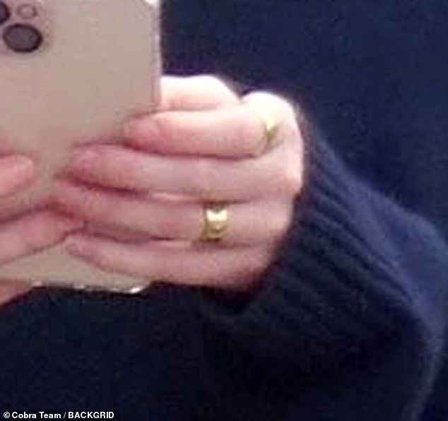 The actress, 28, showed off a chunky gold band on her engagement ring finger as she hinted the property developer had popped the question