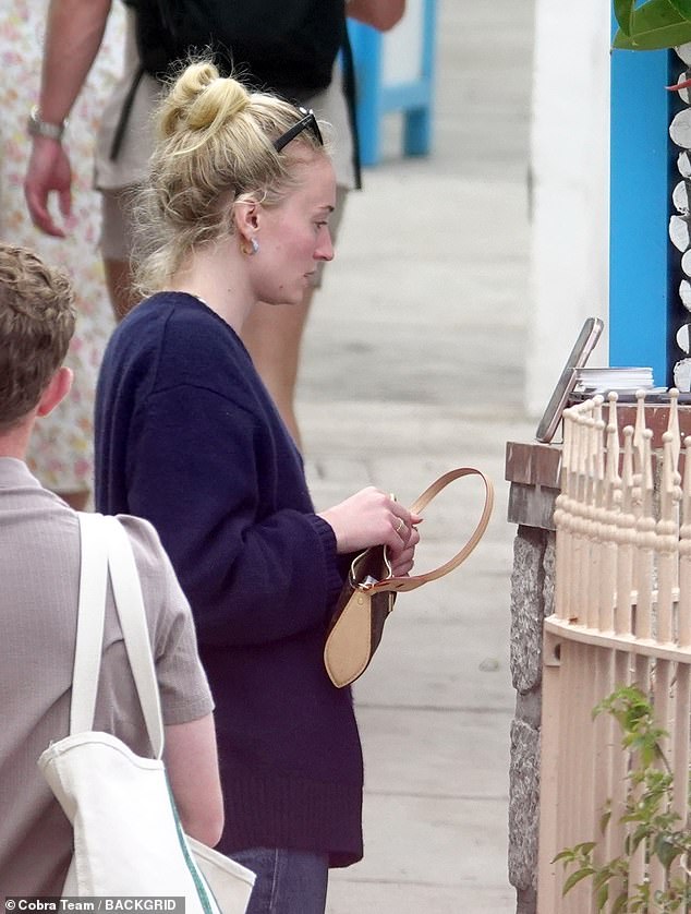 It looked like she was using her phone as a mirror as she balanced it against the wall