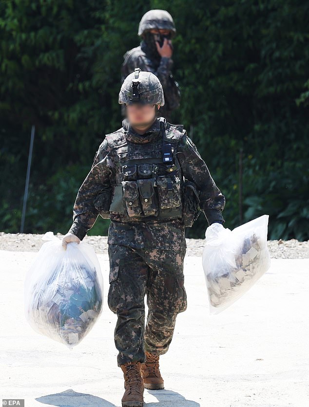 South Korean soldiers collect balloons believed to have been sent by North Korea and found on a hill in Pyeongtaek on Wednesday.  About 200 such balloons have been discovered across the country so far, military and police sources said, adding that they mainly contain garbage and other debris.