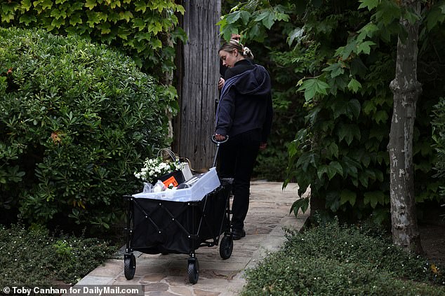 Photos show workers carrying cartloads and buckets of flowers along a flagstone path toward the estate