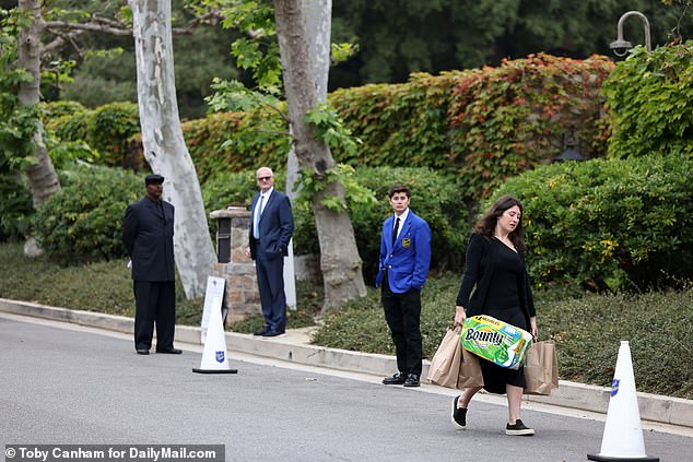 Parking attendants in blue suits with coat of arms are ready to park the luxury cars in which the guests will surely arrive