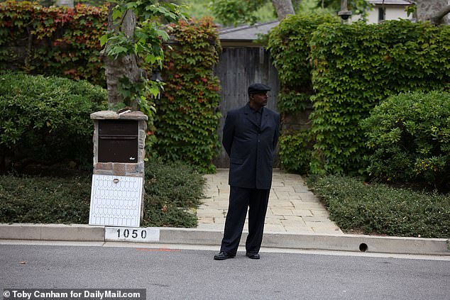 There also appears to be an increased security presence.  The photos show men in dark jackets patrolling the street in front of the Bel Air mansion