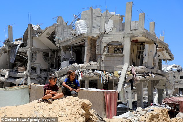 If the talks last longer, the ceasefire would last as long as it takes to reach an agreement.  In the photo: Palestinian children sit near a destroyed house in the southern Gaza Strip