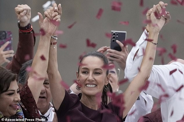 Sheinbaum raises her arms after speaking at her final campaign rally at the Zocalo in Mexico City