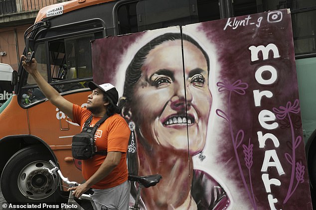 A Sheinbaum supporter takes a selfie with a campaign poster during her closing campaign rally