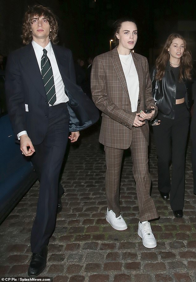 Anya's husband Malcolm McRae (left) looked dapper in a sharp suit and striped tie