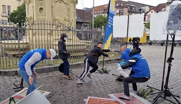 The rampage began when a man dressed in a dark hooded jacket and tracksuit (seen center right) tackled a BPE member to the ground and began violently brandishing a large knife at him.