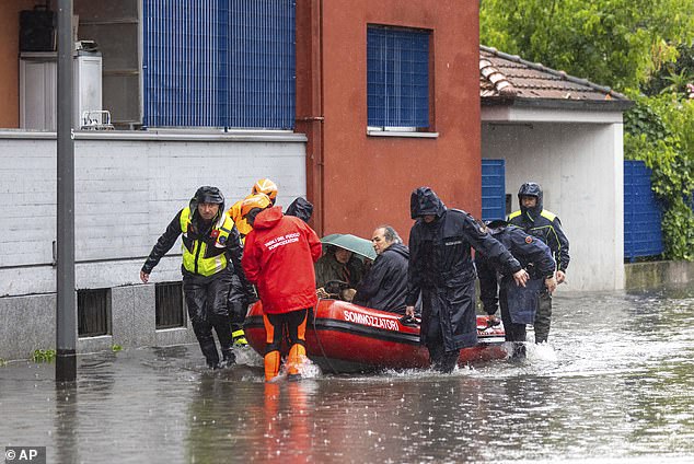 Firefighters use a rubber boat to evacuate people after part of Milan was flooded on May 15