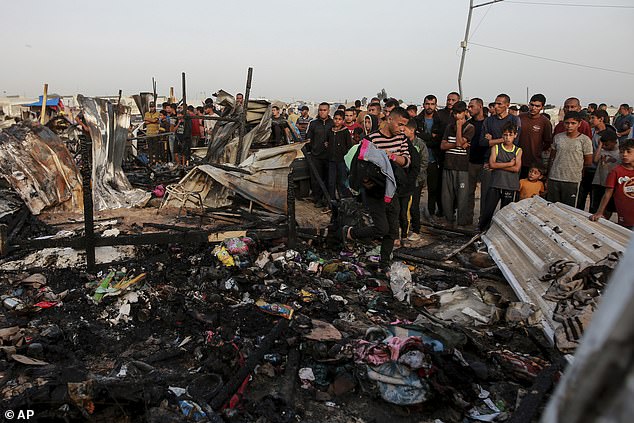 Palestinians look at the destruction after an Israeli attack that left displaced people in Rafah, Gaza Strip