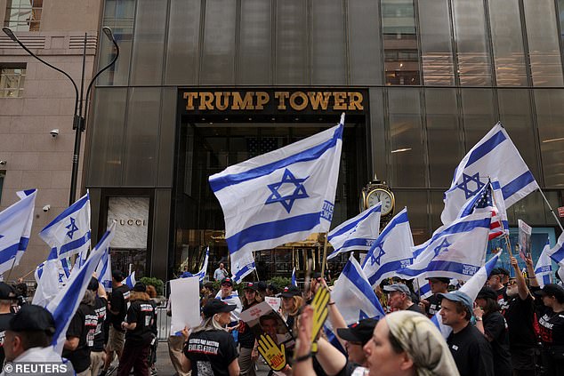 Parade goers march past Trump Tower on 5th Avenue