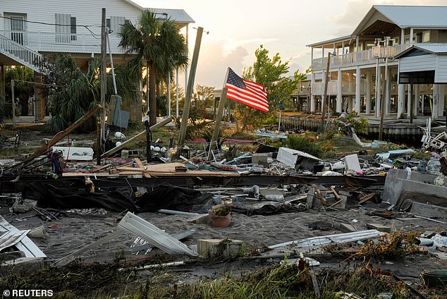 The weather can also be brutal, with hurricanes common and ever-present.  Pictured is an American flag amid the wreckage of a home after a hurricane in Horseshoe Beach, Florida last August