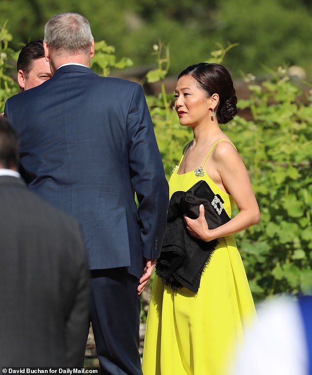 A guest wore a lime-colored dress with a black bag for Rupert Murdoch and Elena Zhukova's wedding