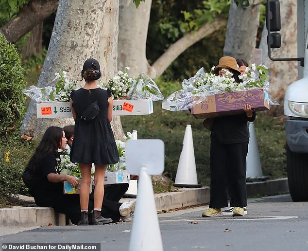 Two women carry flower arrangements for the wedding of Rupert Murdoch and Elena Zhukova