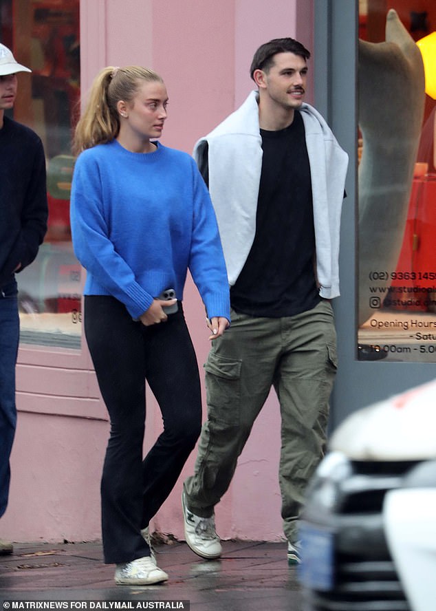 Grace dressed casually for the outing, wearing a sky blue knit sweater, black flared leggings and white sneakers