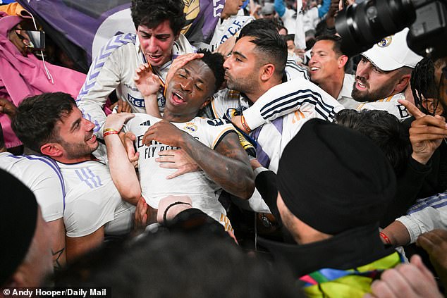 Vinicius Jr, who scored his side's second goal that evening, is mobbed by adoring Madrid fans