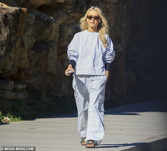 Jackie looked content as she walked along a boardwalk looking out to sea