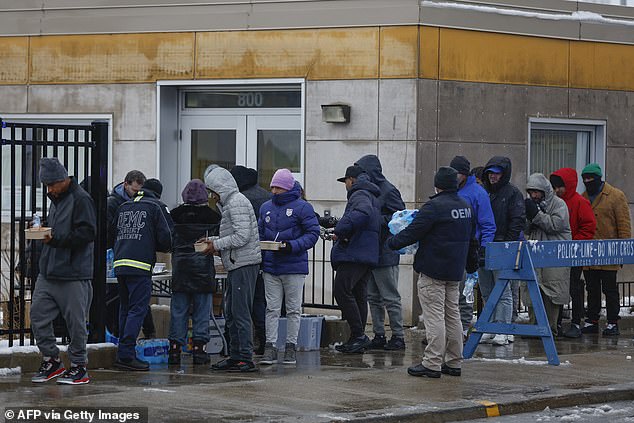 Migrants recently arrived in Chicago receive food during a winter storm