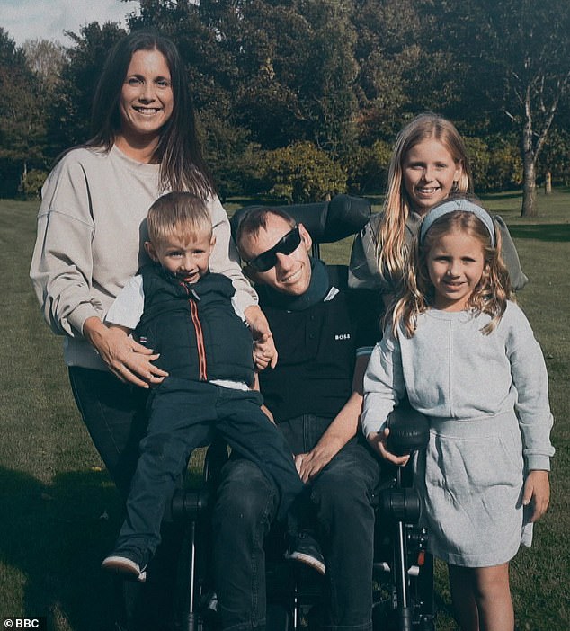 Rob poses with his wife Lindsey (left), eldest daughter Macy (back right), second daughter Maya (front right) and son Jackson (sitting on the arm of the wheelchair)