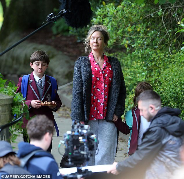 The young actors wore school uniforms as Renee held their hands and walked them to school