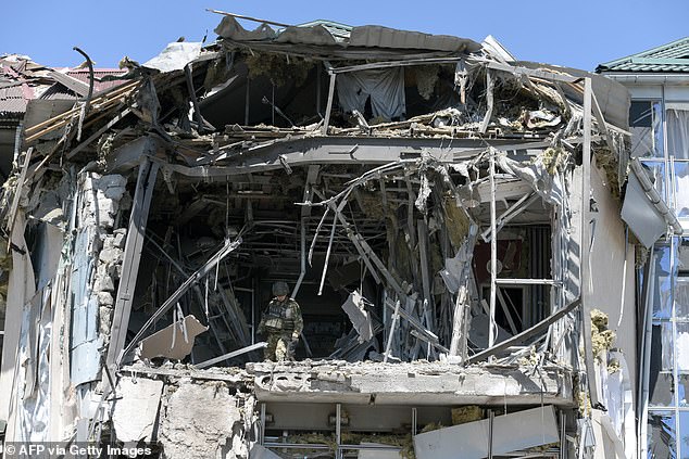 Military investigators work at the site of the damaged building that houses the Paradise restaurant after a strike in Donetsk, Russia-controlled Ukraine, earlier this month