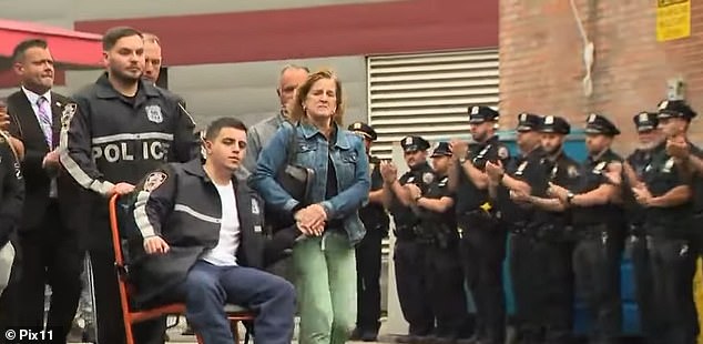 The NYPD officers involved in the shooting were filmed leaving Elmhurst Hospital in daylight several hours later.  One was wheeled out (pictured) as colleagues gave them a standing ovation