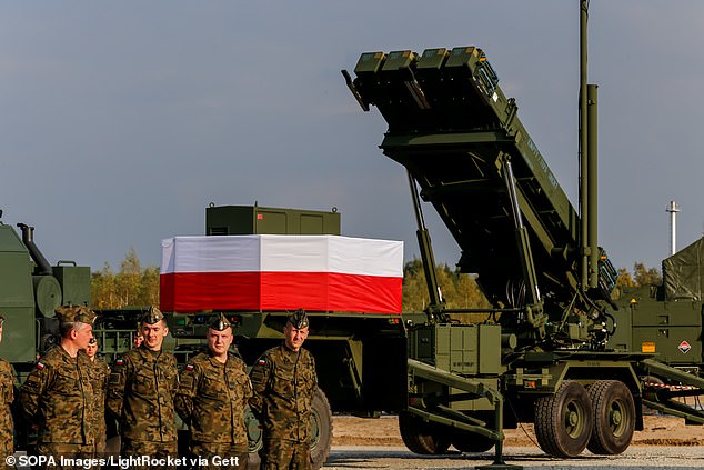 Army soldiers stand next to a Patriot anti-aircraft battery