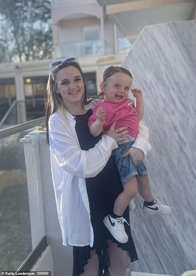 Maddy, a full-time mother, beams in the photo as she holds her one-year-old son Liam, pictured in his mother's arms