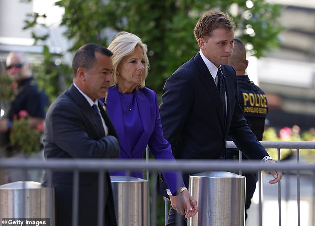 First lady Jill Biden (center) walks into the courthouse on Monday with an aide (left) and Naomi Biden's husband Peter Neal (right), as the president remained seated at the couple's home in Wilmington, Delaware