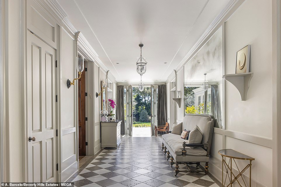 The hall at the front has a black and white tiled floor and French doors