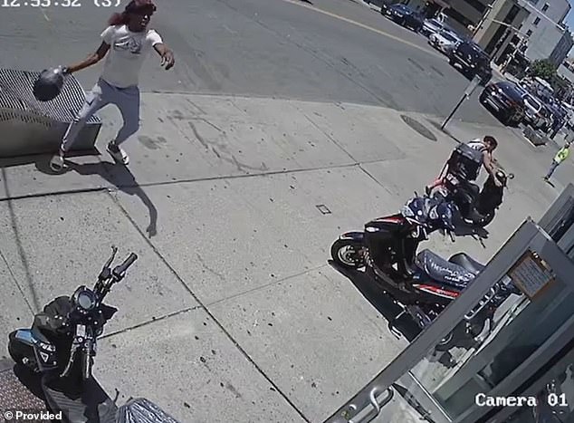 The suspect takes aim again and throws his bicycle helmet against the windows