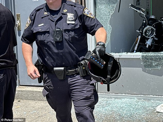 Police officers respond after the suspect threw it at the windows of the store