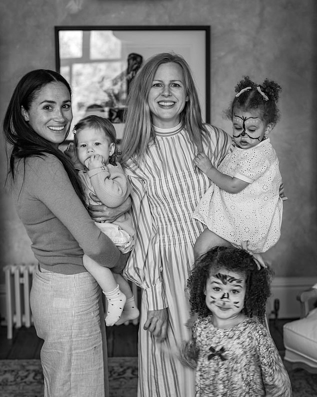 Photos shared by friend of the Sussexes and professional photographer Misan Harriman include a photo of Meghan holding Lilibet as she stands with photographer's wife Camilla Holmstroem and their two daughters at Lilibet's first birthday