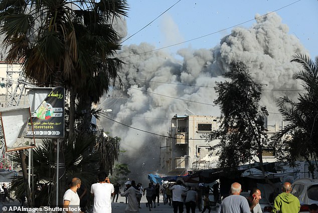 Dust and black smoke rise shortly after an Israeli airstrike targeted a residential building in the city of Bureij