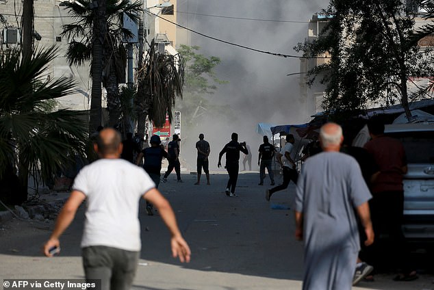 Palestinians flee shortly after an Israeli airstrike targeted a residential building