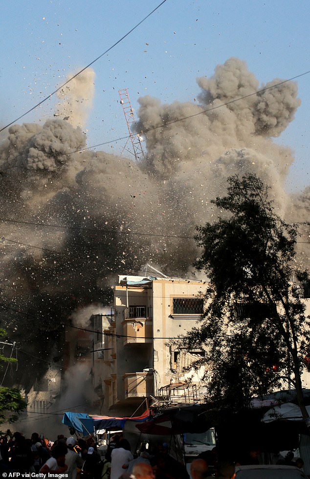 Dust and debris fall from the residential building that was the target of an Israeli airstrike