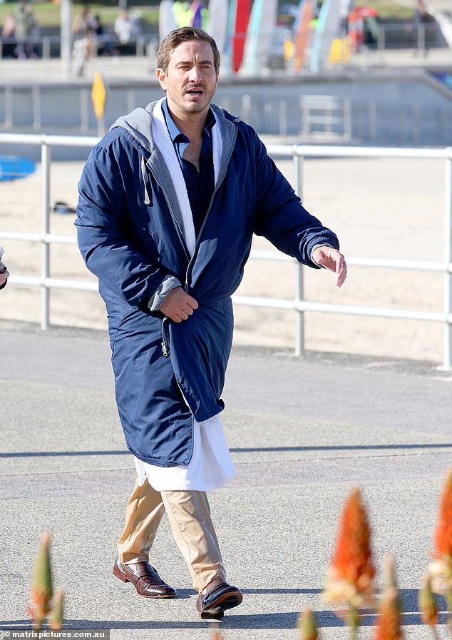 He kept warm with a fluffy white robe and a large blue coat